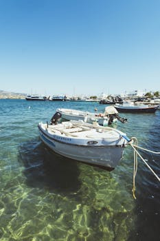 Serene view of boats docked at Antiparos harbor in Greece, under a clear blue sky.